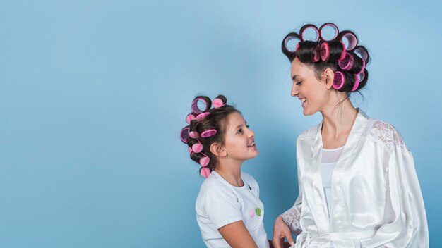 Happy mother and daughter in curlers 