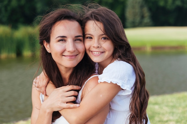 Happy mother and daughter hugging outdoors portrait