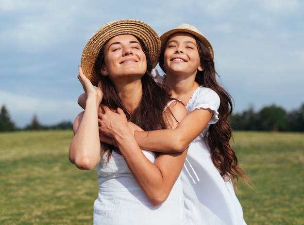 Happy mother and daughter posing in nature