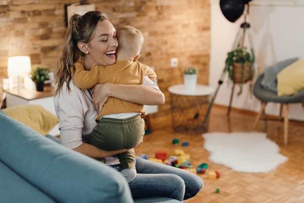 Foto gratuita madre felice che abbraccia il suo piccolo figlio a casa