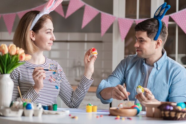 Happy mother and father painting eggs together