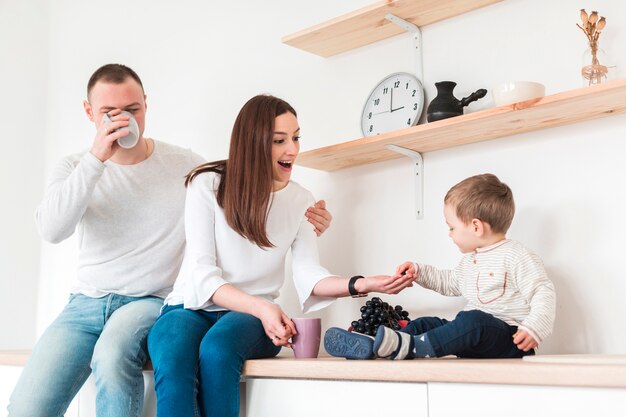 Happy mother and father with child in the kitchen