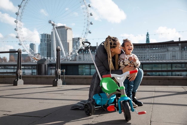 Happy mother and kid with tricycle full shot