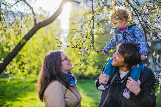 Happy mother looking at her son on his father's shoulders