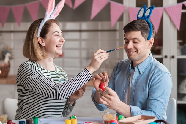 Happy mother painting father for easter