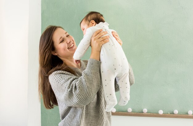 Happy mother playing with cute baby