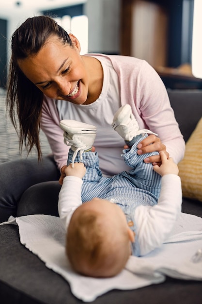 リビングルームのソファで男の子と遊ぶ幸せな母親