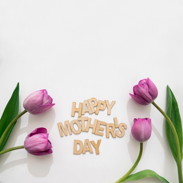 Днем материнская надпись и четыре тюльпана