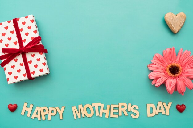 «Счастливый день матери» надпись с подарочной коробкой, цветами и сердцами