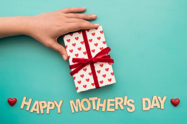 "happy mother's day" lettering with gift box and hand