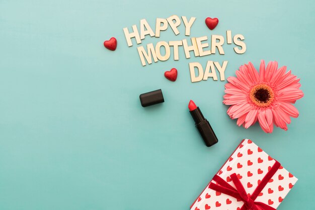 "happy mother's day" lettering with lipstick, gift box and flower