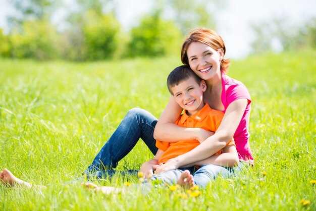 Happy mother and son in the spring meadow outdoor portrait