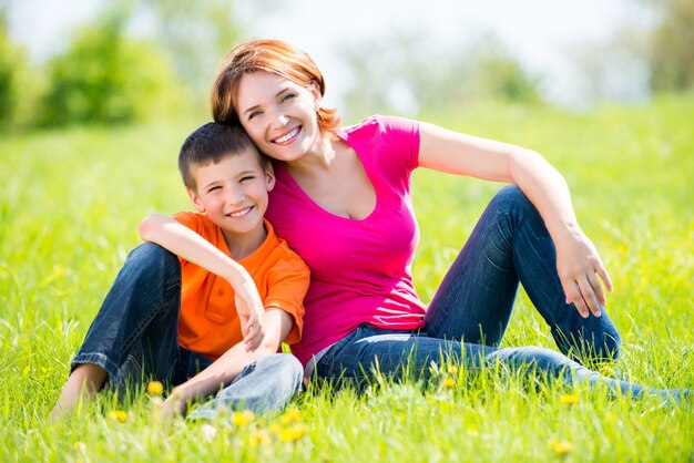 Happy mother and son in the spring meadow outdoor portrait