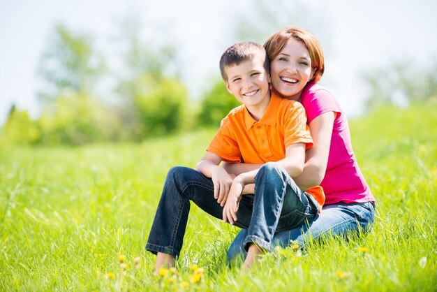 Happy mother and son in the spring meadow outdoor portrait