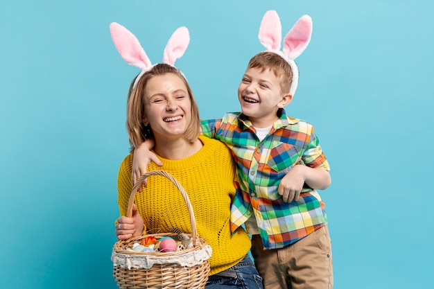 Happy mother and son with basket of painted eggs