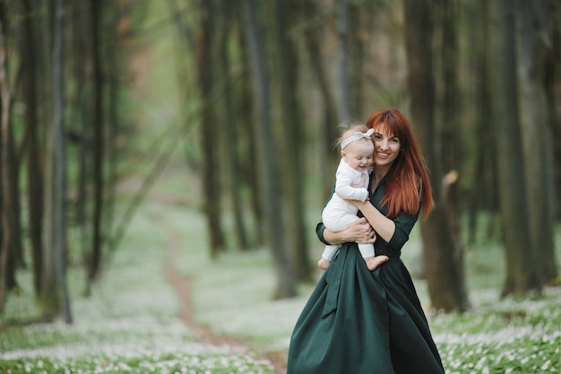 Happy mother tightly holds her little daughter