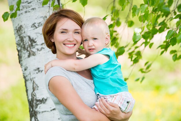 Happy mother and toddler son at field -  outdoor portrait