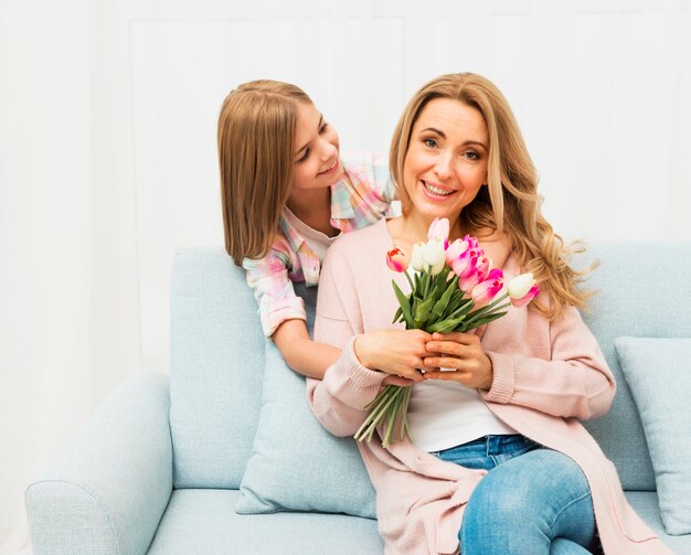 Счастливая мама с цветами от дочери