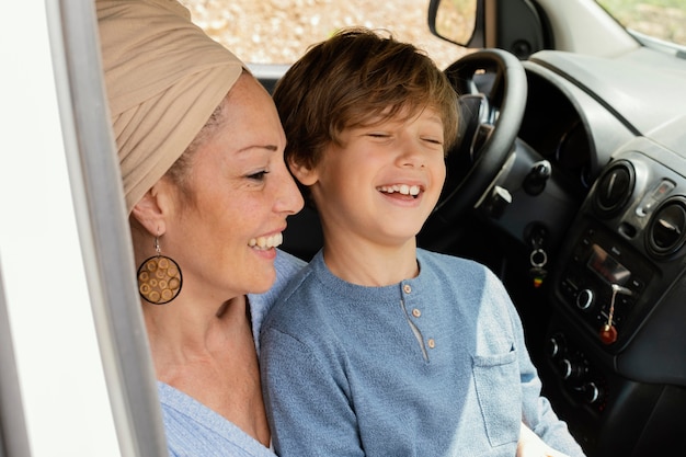 Foto gratuita felice madre con figlio in viaggio in auto