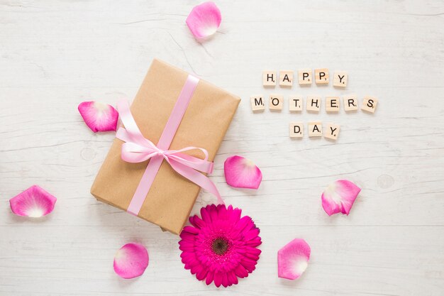 Happy Mothers Day inscription with gift box and gerbera