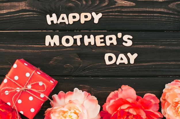 Foto gratuita iscrizione di happy mothers day con regalo e fiori