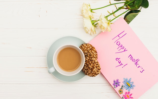 Foto gratuita iscrizione di happy mothers day con rose e caffè