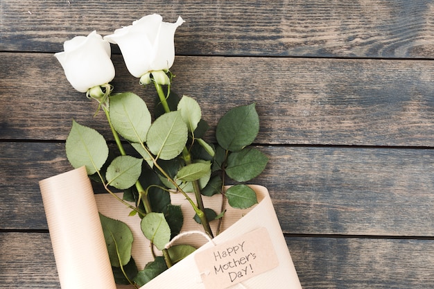 Happy Mothers Day inscription with roses on table