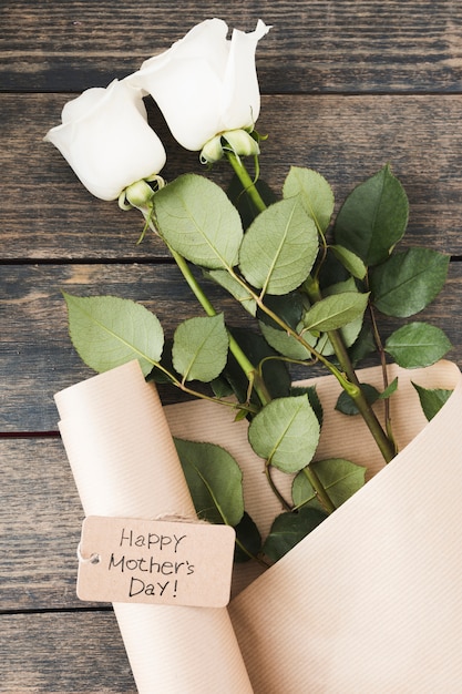 Happy Mothers Day inscription with white roses on table