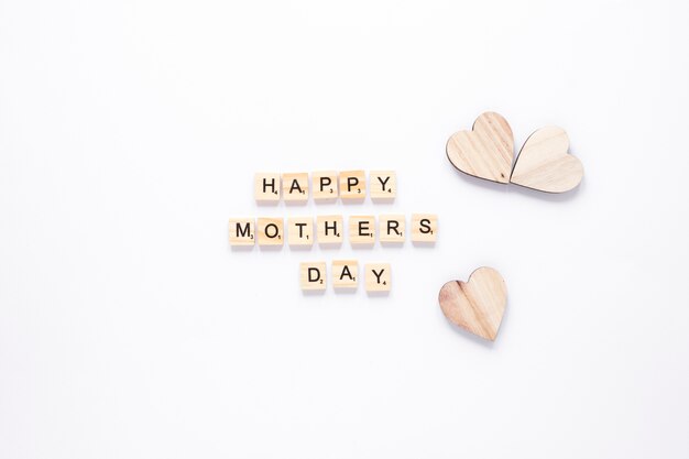 Happy Mothers Day inscription with wooden hearts 