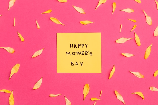 Happy mothers day title on paper among flower petals