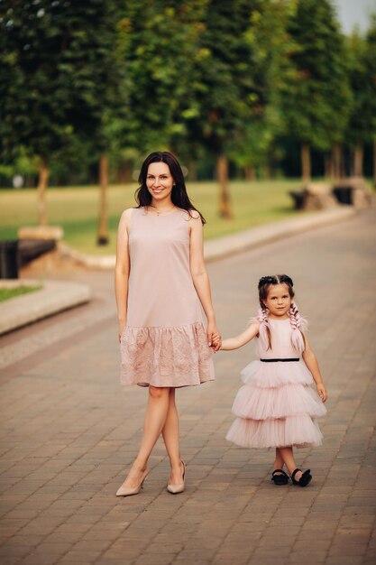 小さな娘と散歩に行く幸せなお母さん
