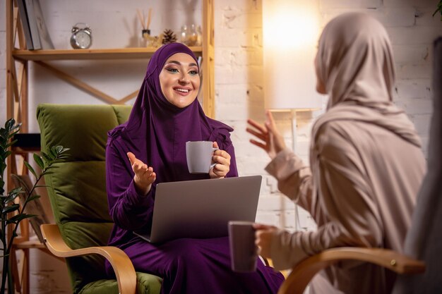 オンラインレッスン中に自宅で幸せなイスラム教徒の女性。