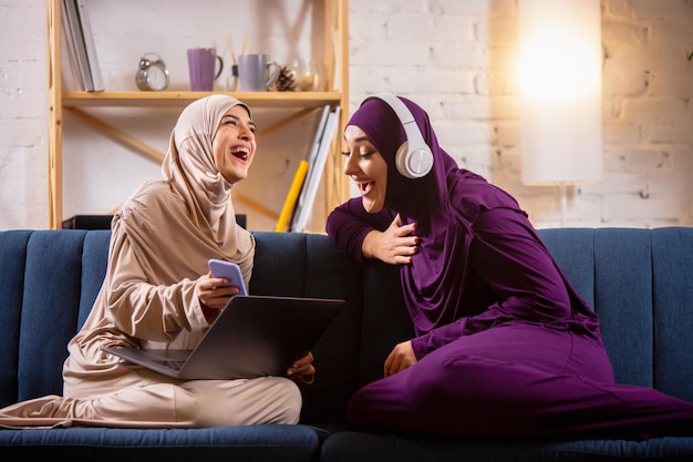 Felice donna musulmana a casa durante la lezione online.