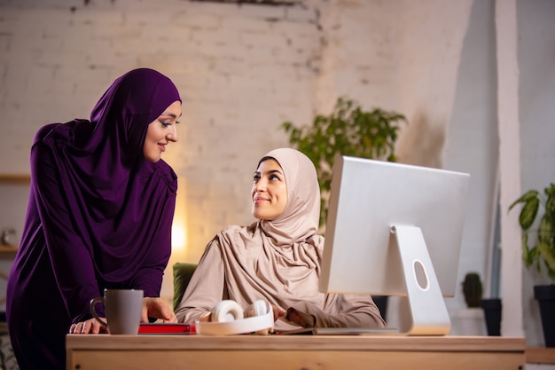 Счастливая мусульманская женщина дома во время онлайн-урока. технологии, дистанционное образование, этничность