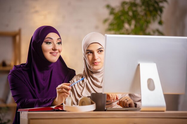 Happy muslim woman at home during online lesson.