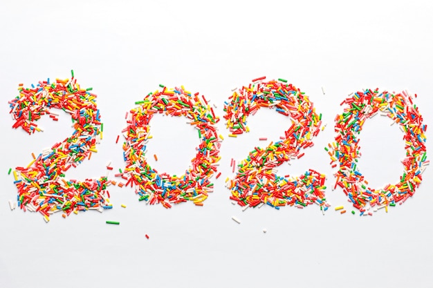 Free photo happy new 2020 year. colorful number shape with bright rainbow sugar sprinkles isolated on white