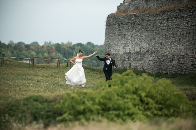 Happy newlyweds dancing on the grass