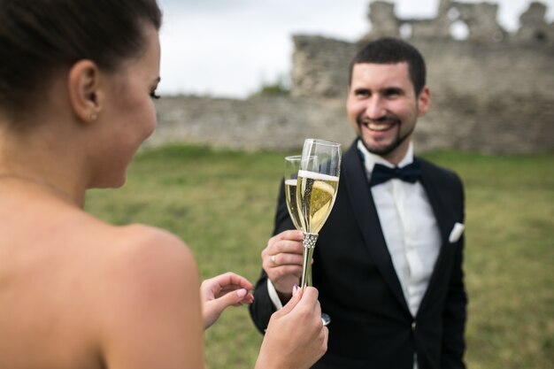 Happy newlyweds toasting outdoors