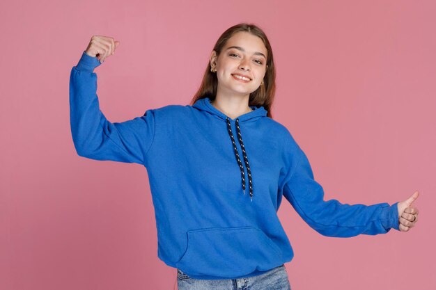 Happy nice female gesturing with thumbs up while having fun and smiling at camera