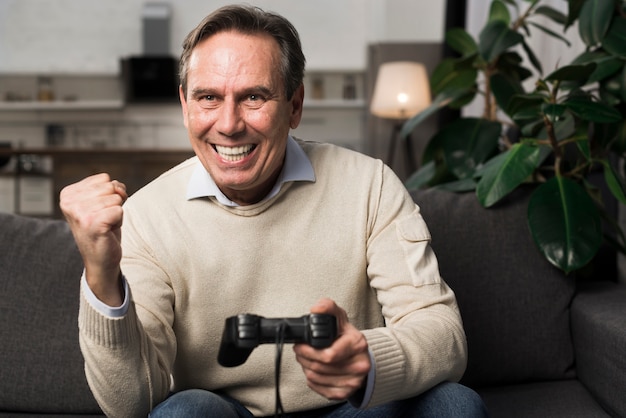 Happy old man playing videogame