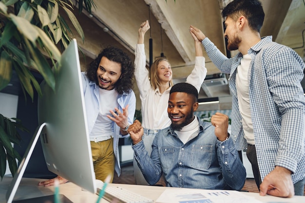 幸せな大喜びのビジネスチームは企業の勝利を祝います