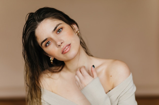 Free photo happy pale girl posing on light wall. indoor portrait of inspired brunette lady.