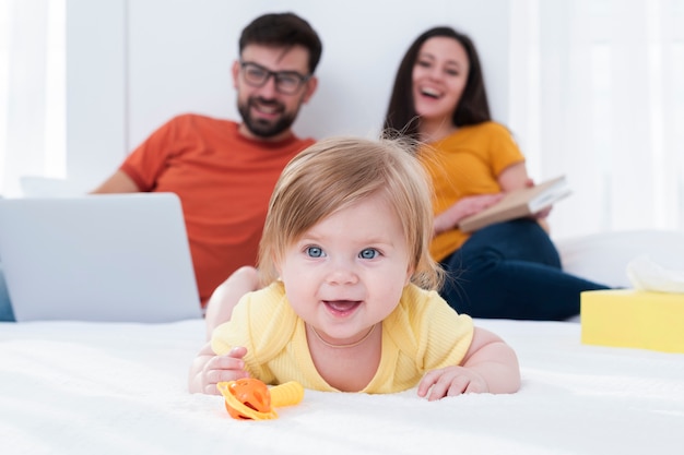 Happy parents and baby in bed