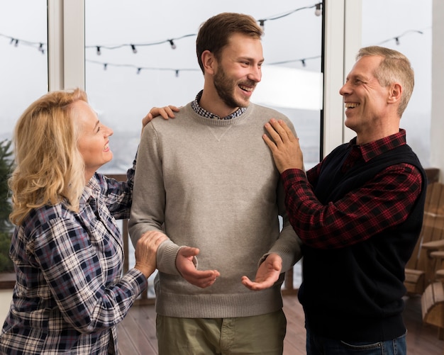 Happy parents embracing son at home