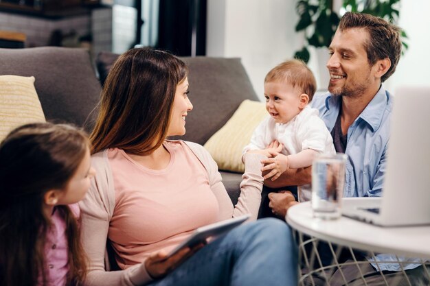 Happy parents enjoying with their daughter and baby boy at home