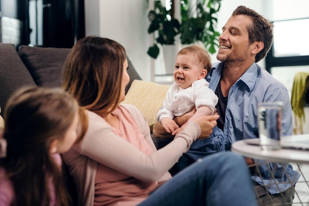 Foto gratuita genitori felici che si divertono con i loro bambini piccoli mentre trascorrono del tempo insieme a casa