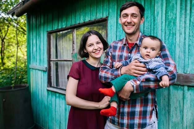 Happy parents posing with child standing outside