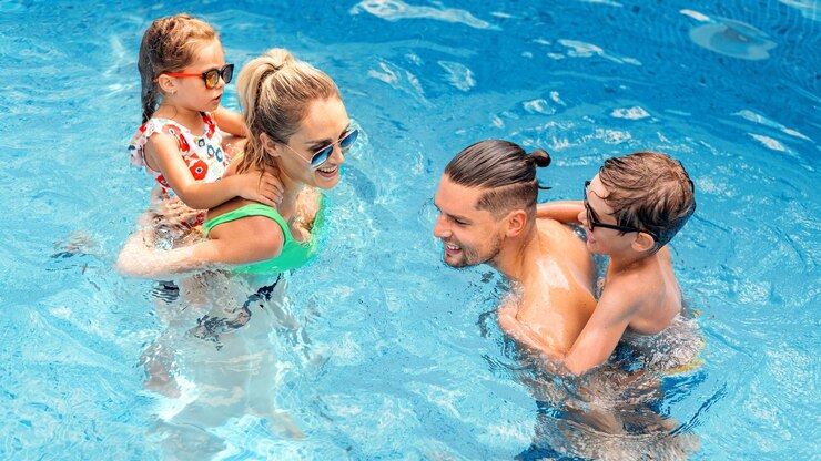 Free Photo happy parents and two kids are swimming in the pool