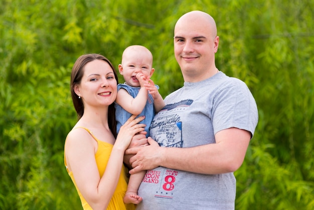 Free photo happy parents with child in nature