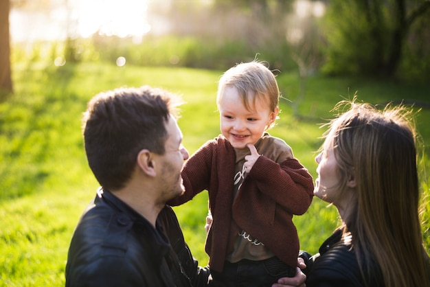 Free photo happy parents with child in nature